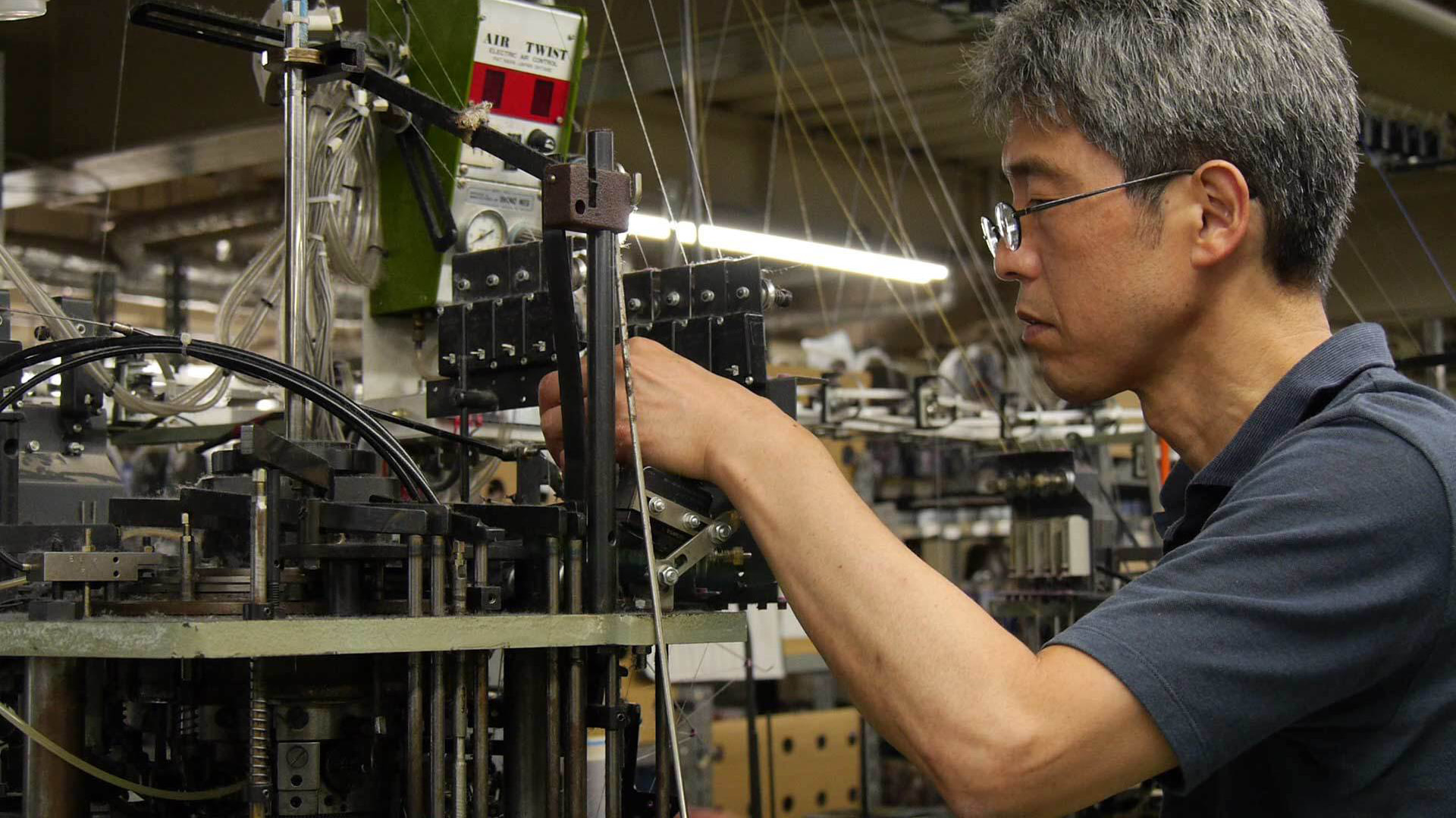 日本製の靴下製造機を管理する職人
